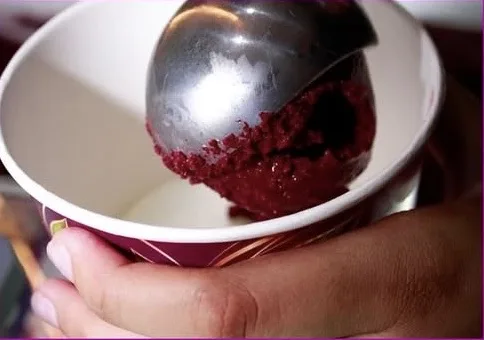 Açaí sendo servido com concha em copo da marca