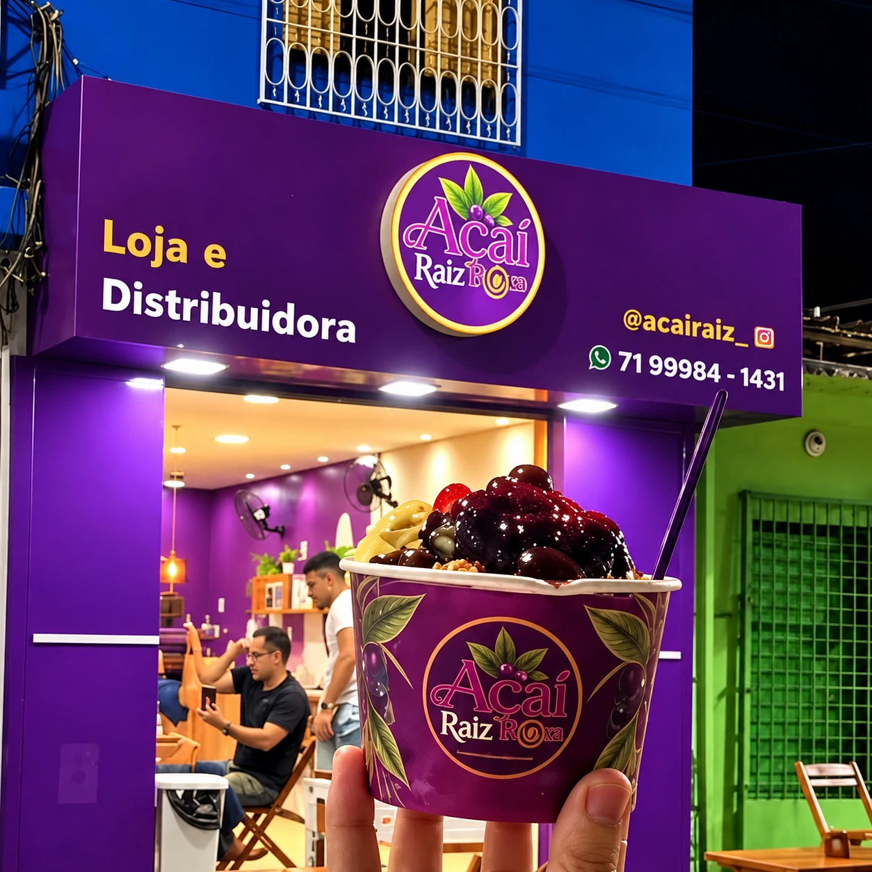Copo de açaí em primeiro plano diante da fachada roxa da Açaí Raiz Roxa